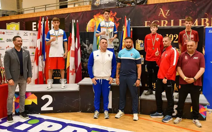Sportivi și antrenori fotografiați lângă podium