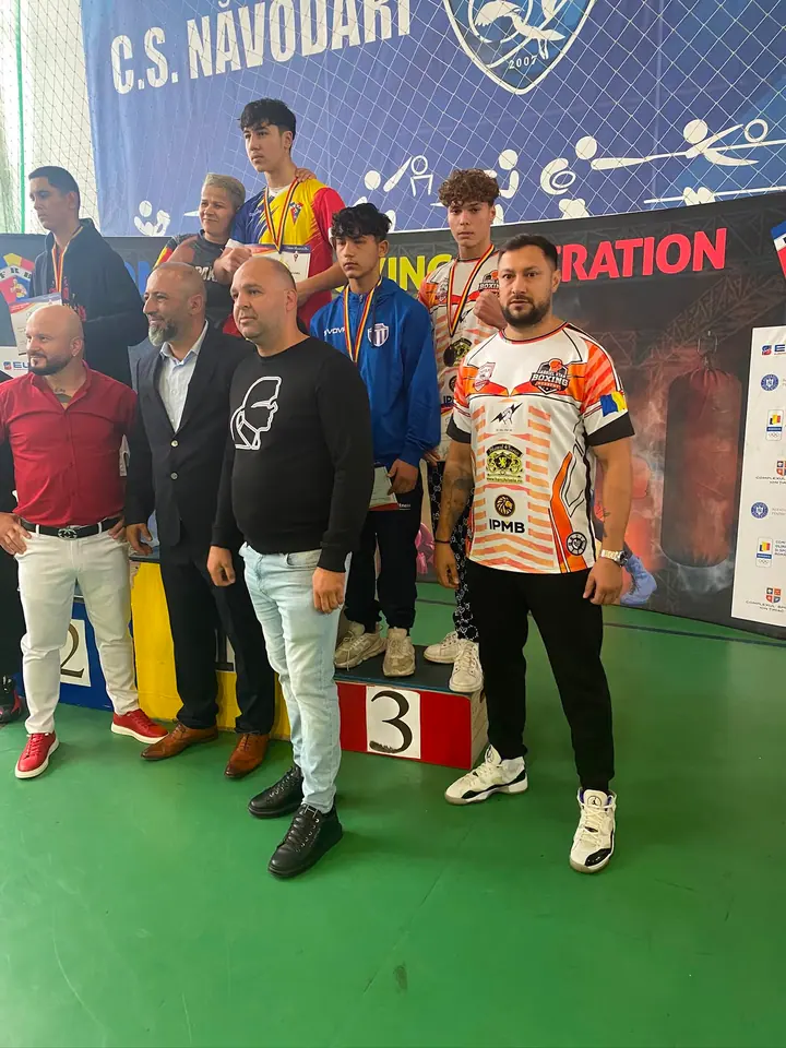 Sportiv premiat pe podium alături de antrenor