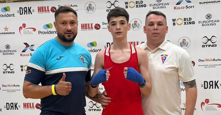 Tânăr boxer alături de antrenori după competiție